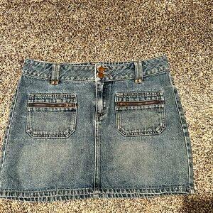 Tilted denim skirt with pockets in the front with zippers